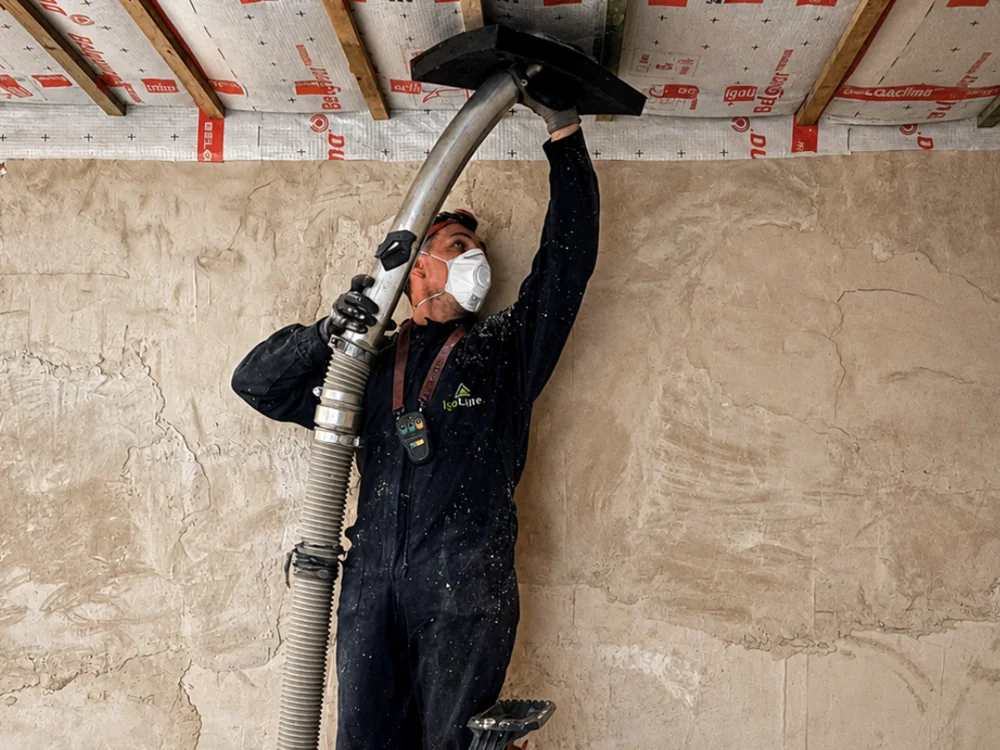 Slimane d'IsoLaire insufflant de l'isolant cellulose dans un plafond